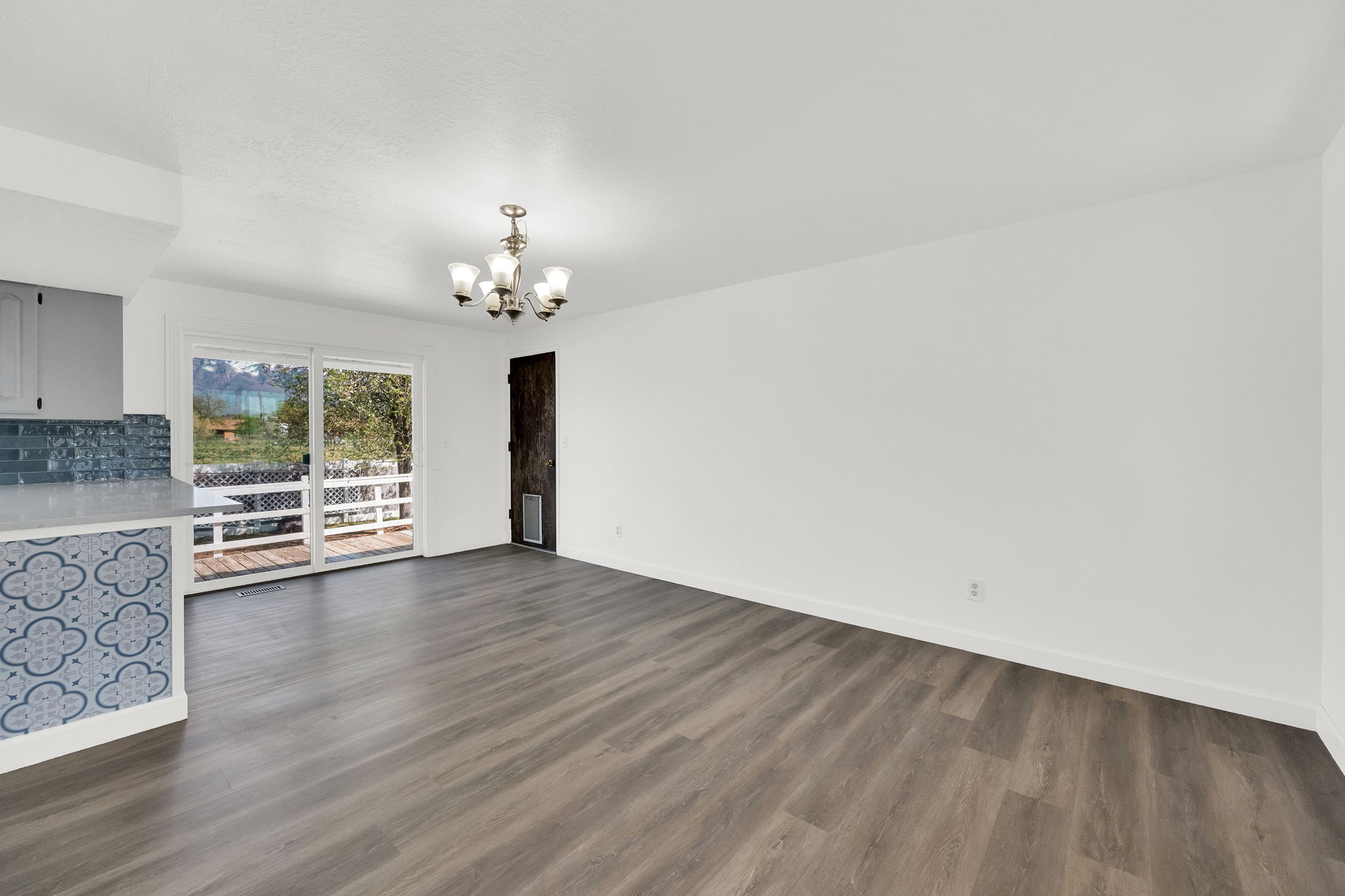 Unfurnished living room with a chandelier and dark wood-type flooring