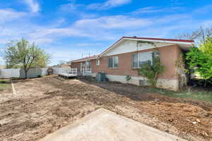 Rear view of house featuring a fenced backyard, brick siding, and a shed