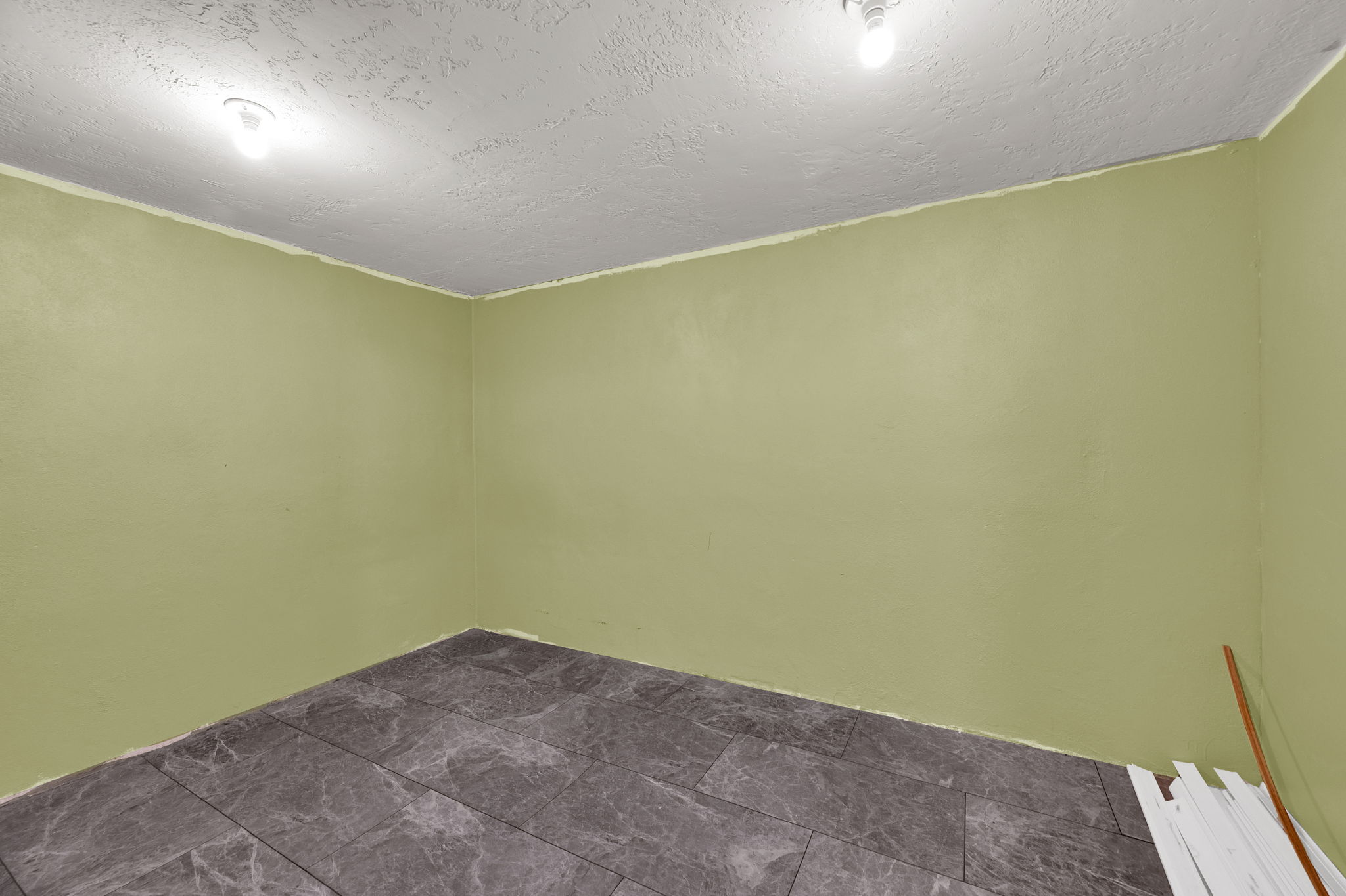 Spare room with a textured ceiling and dark stone finish floors