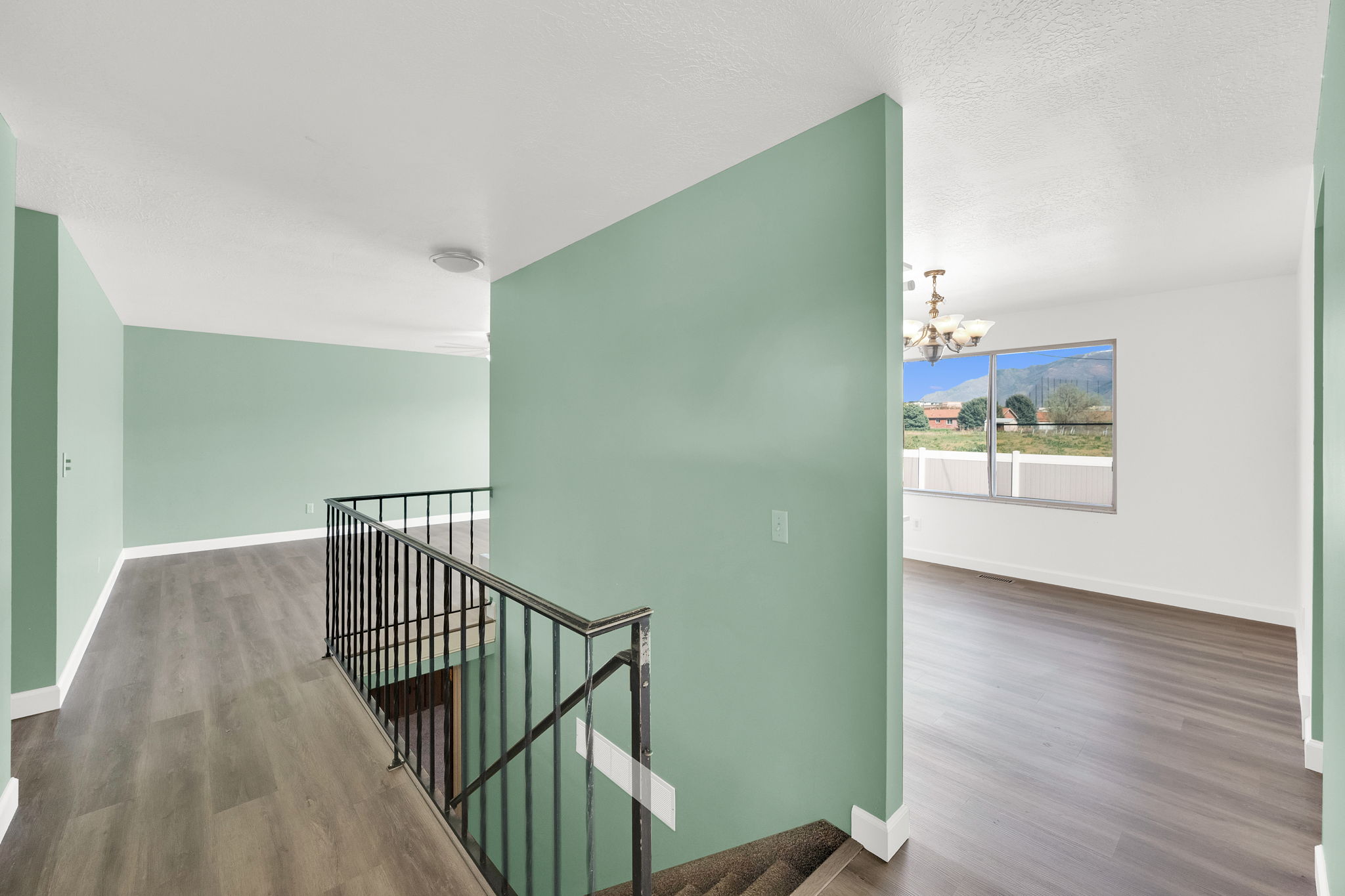 Stairs featuring suspended lighting and wood finished floors