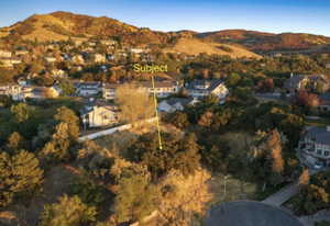 Aerial perspective of suburban area featuring a mountain backdrop and property boundaries highlighted
