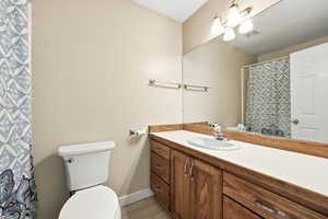 Bathroom with a shower with curtain and vanity