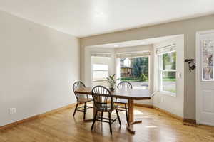Dining area with light wood-type flooring and baseboards