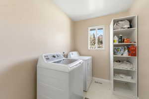 Laundry area featuring lofted ceiling and independent washer and dryer