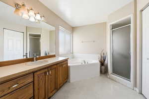 Full bath with a closet, a shower stall, vanity, and a bath