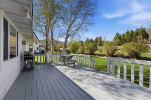 Wooden deck featuring a grill