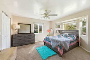 Bedroom featuring a closet, a ceiling fan, and light colored carpet