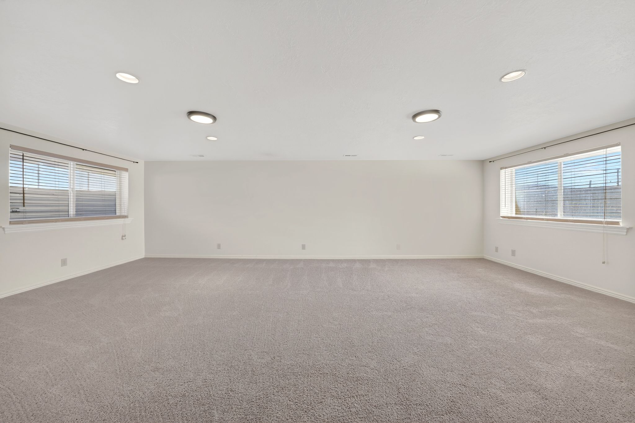 Carpeted empty room featuring plenty of natural light and recessed lighting