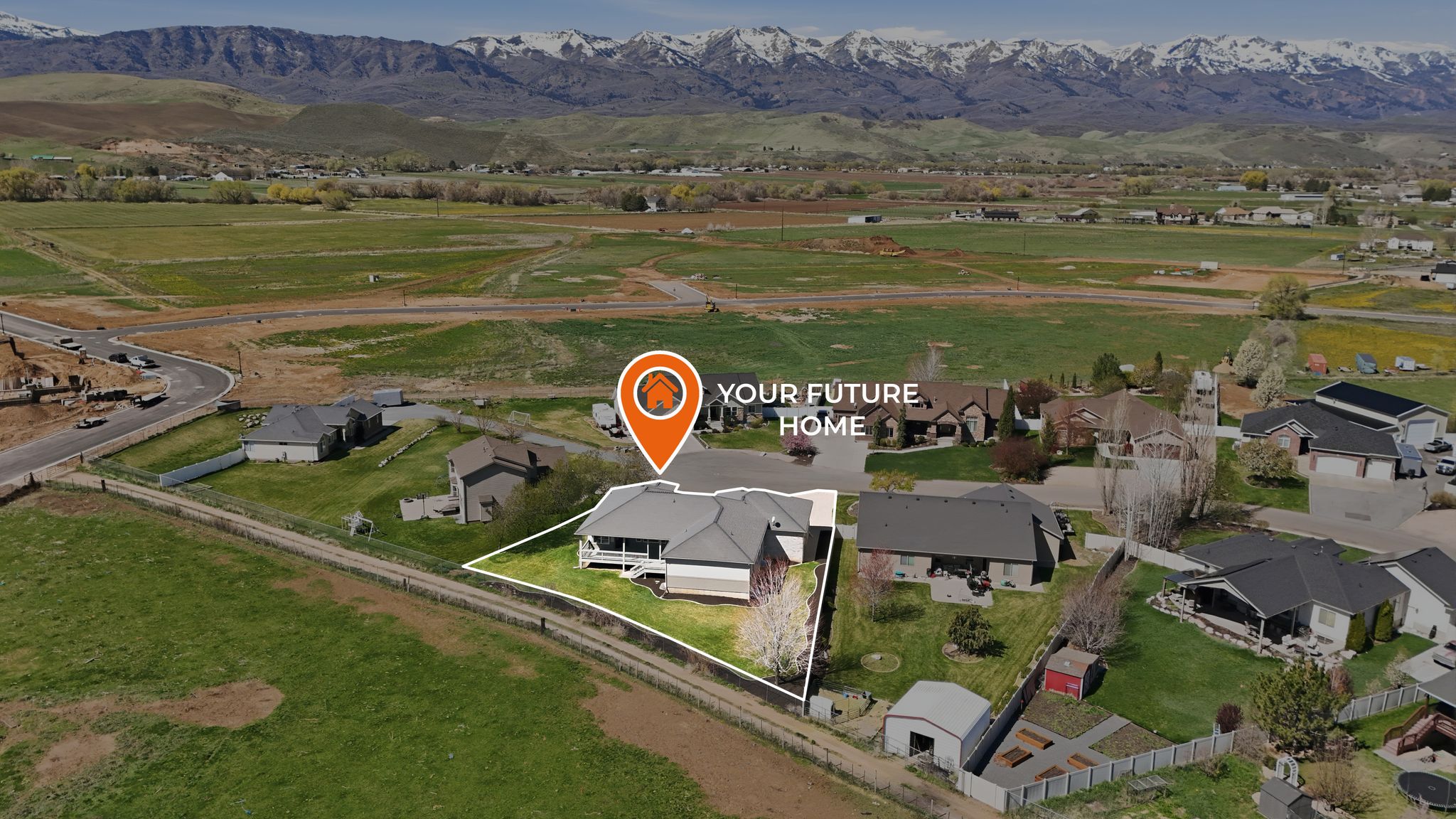 Aerial view of property's location with property boundaries highlighted, a mountainous background, and nearby suburban area
