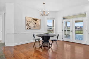 Dining space featuring french doors, wood-type flooring, and suspended lighting