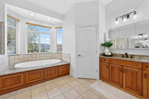 Full bathroom with vanity, light tile patterned floors, a garden tub, and recessed lighting