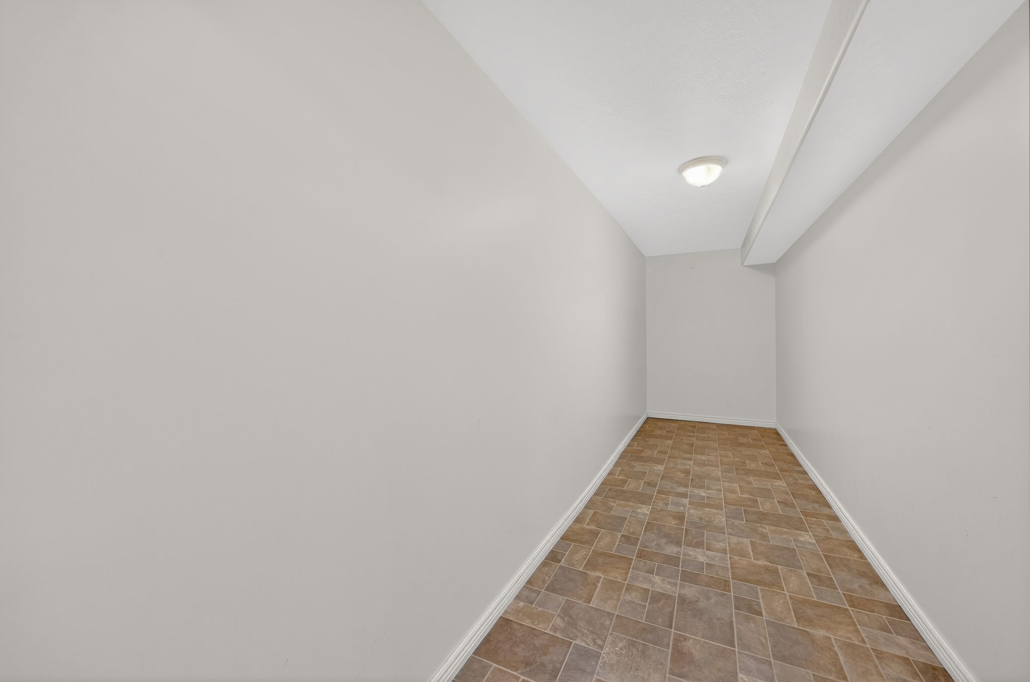 Additional living space featuring stone finish floors and baseboards