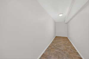 Additional living space featuring stone finish floors and baseboards