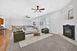 Living area with recessed lighting, a tiled fireplace, and a ceiling fan