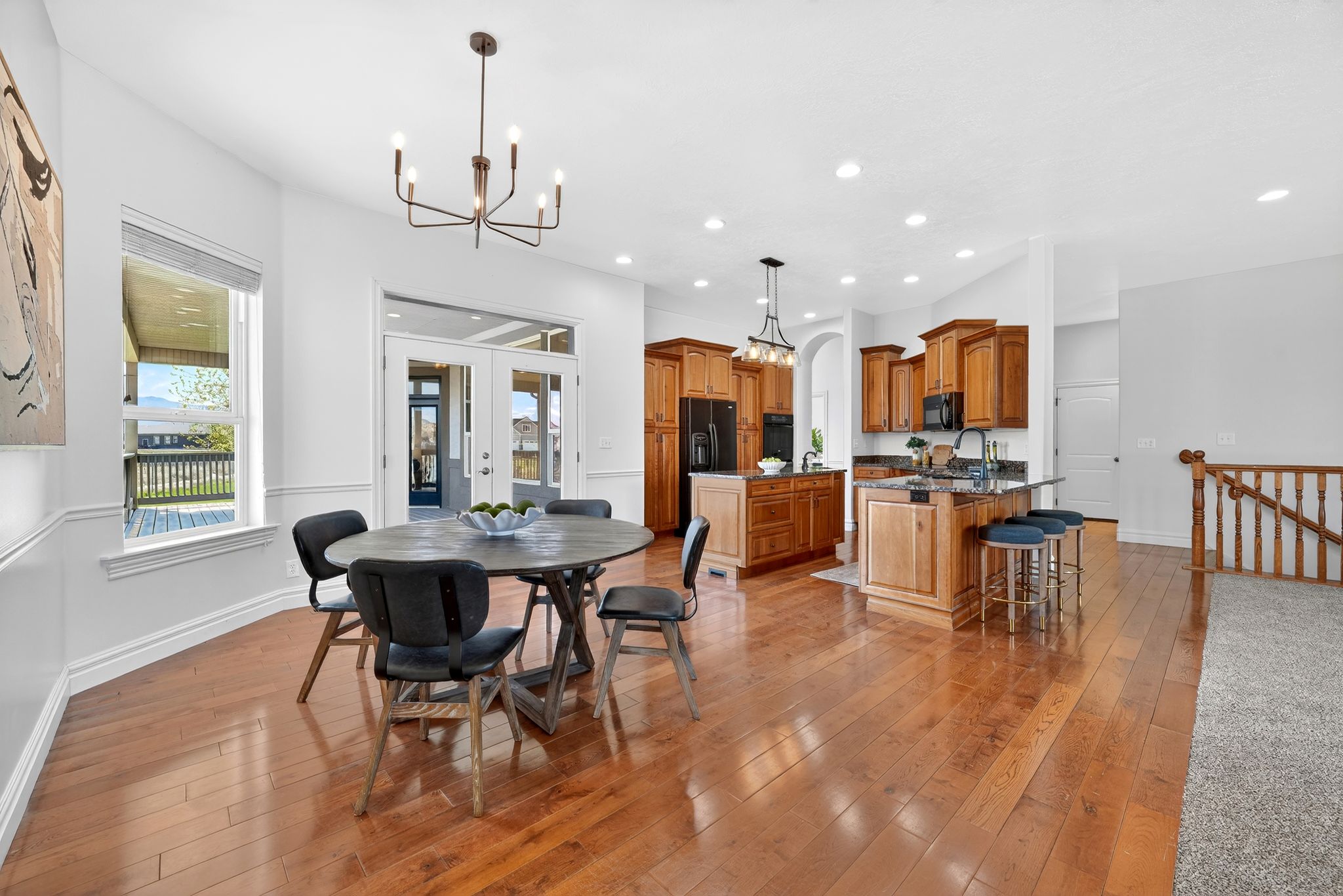 Dining area with a chandelier, light wood-style flooring, and french doors