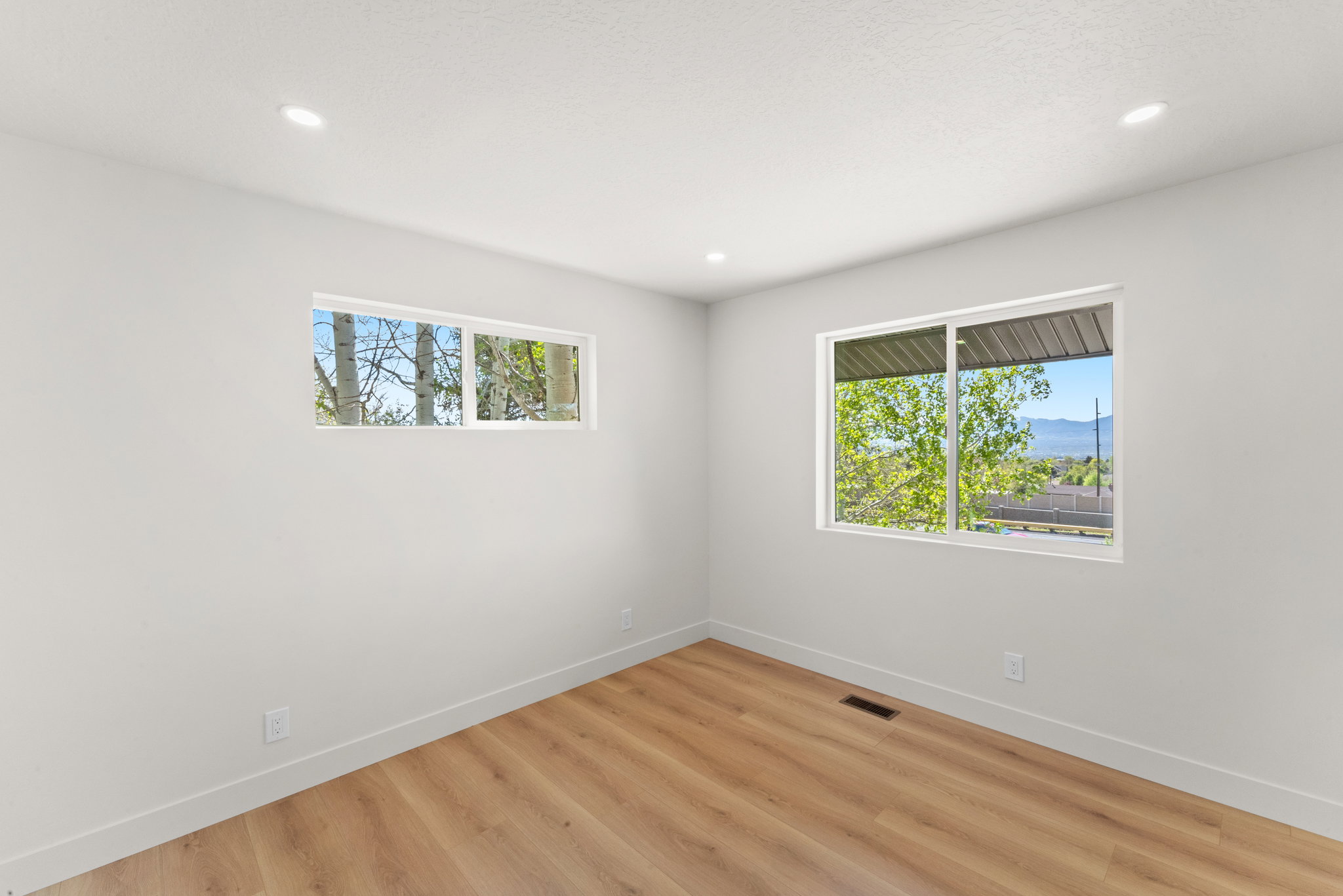 Empty room with light wood-style flooring, recessed lighting, and a mountain view
