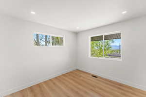 Empty room with light wood-style flooring, recessed lighting, and a mountain view