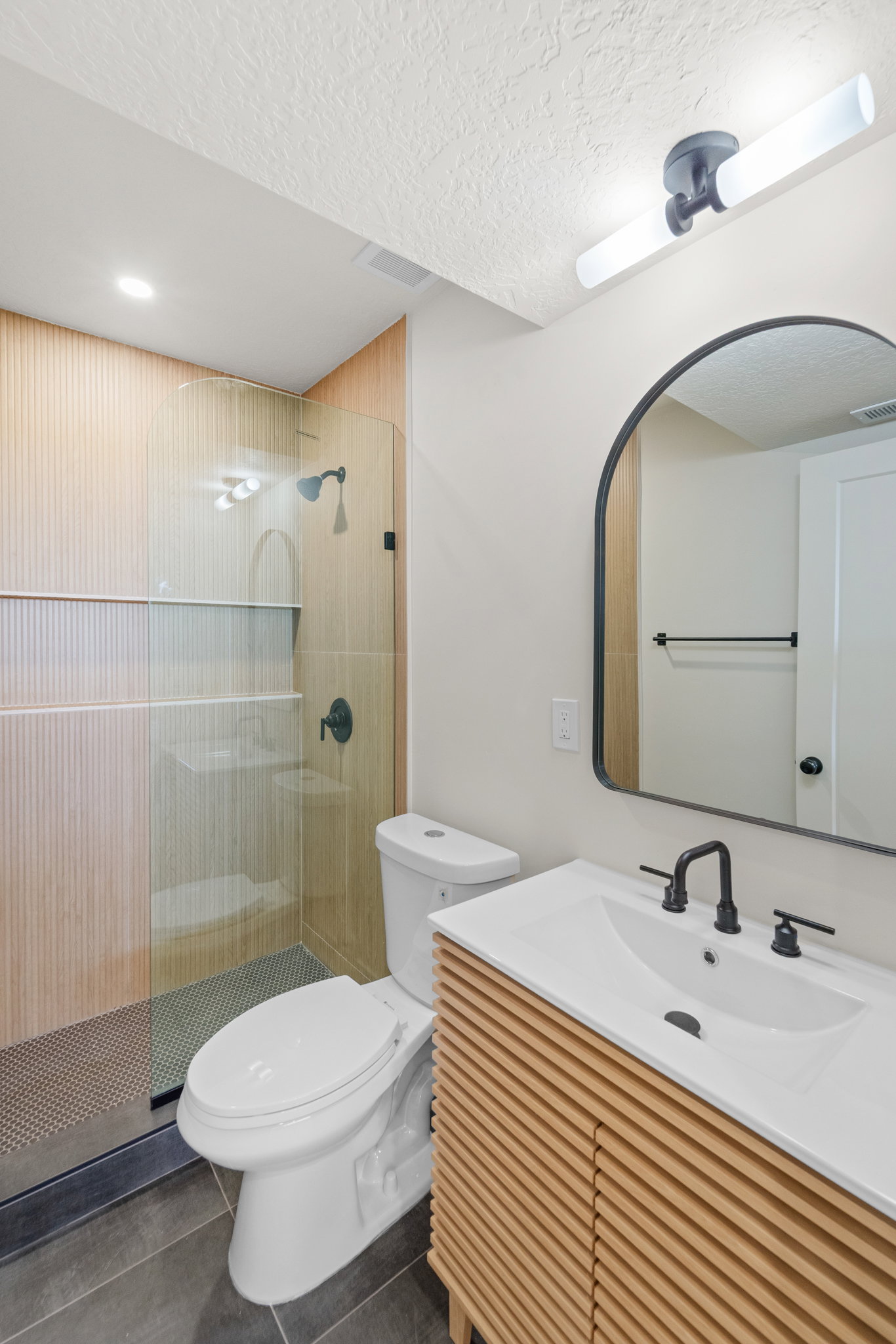 Full bath featuring vanity, a stall shower, tile patterned floors, and a textured ceiling