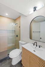 Full bath featuring vanity, a stall shower, tile patterned floors, and a textured ceiling