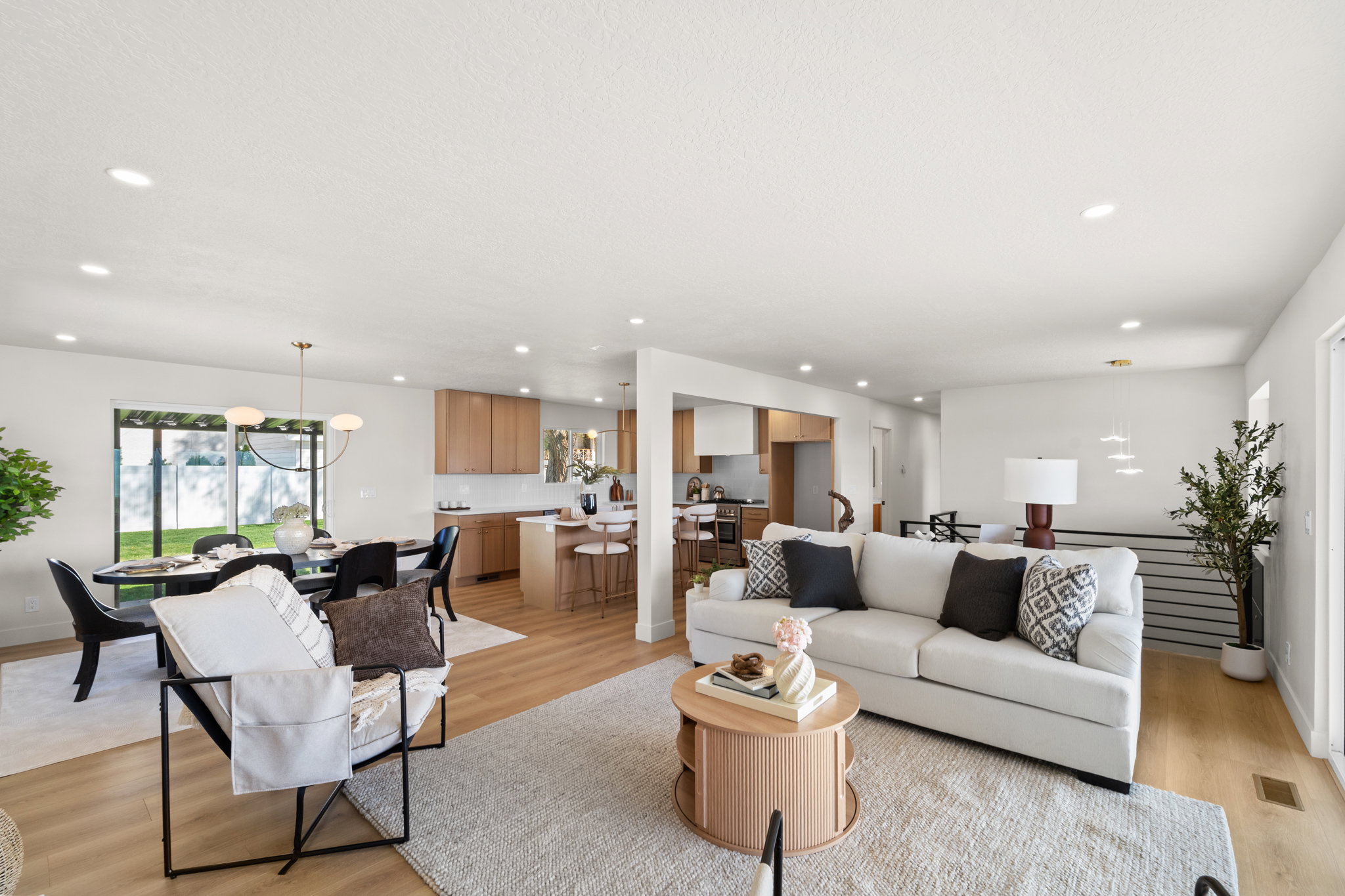 Living room featuring light wood-type flooring and suspended lighting