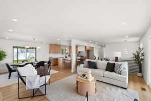 Living room featuring light wood-type flooring and suspended lighting