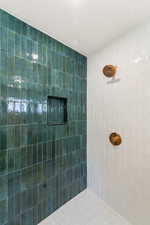 Full bathroom featuring a textured ceiling and a tile shower