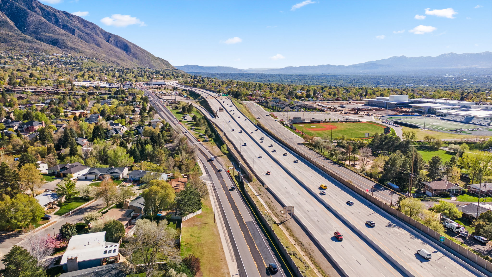 Aerial view of residential area featuring a highway and mountains
