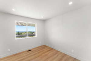 Unfurnished room with light wood-style floors, a mountain view, and recessed lighting