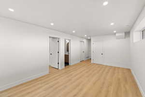 Below grade area with light wood-type flooring and recessed lighting