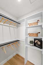 Walk in closet with light wood finished floors