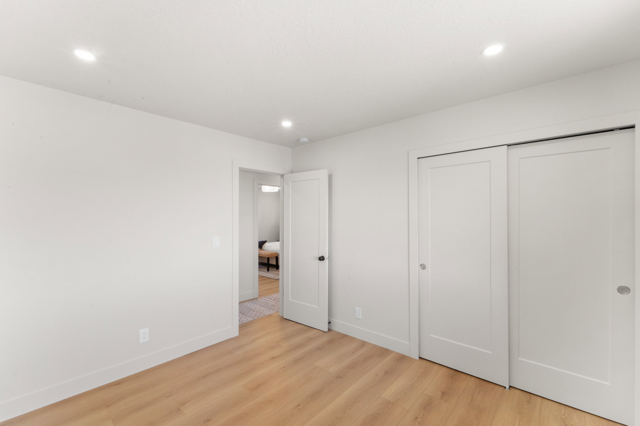 Unfurnished bedroom with light wood-type flooring, a closet, and recessed lighting
