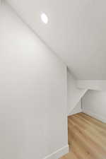 Additional living space with light wood-type flooring and baseboards