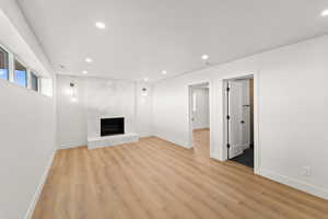 Unfurnished living room with recessed lighting, a fireplace, and light wood-style floors