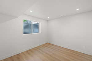 Empty room featuring light wood-type flooring and recessed lighting