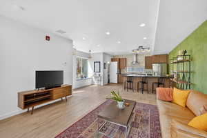 Living room with light wood-type flooring and recessed lighting