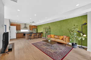 Living room with light wood finished floors and recessed lighting