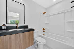 Bathroom featuring vanity, bathing tub / shower combination, and marble look tile flooring