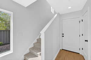 Foyer with stairs and light wood-style floors
