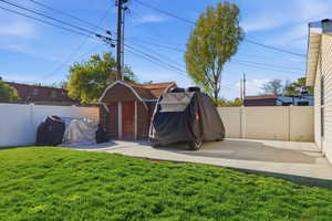 Fenced backyard featuring a storage shed
