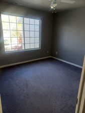 Master bedroom featuring dark colored carpet and a ceiling fan