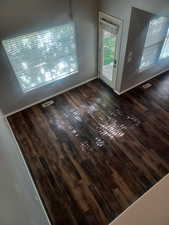 Main level Family room featuring healthy amount of natural light and dark wood-type flooring