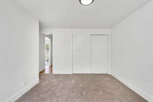 Unfurnished bedroom with carpet flooring and a closet