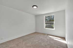 Spare room with carpet and baseboards