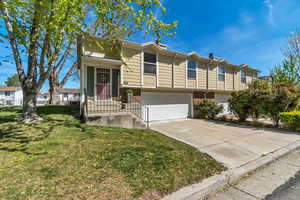 View of front of house featuring brick siding, an attached garage, driveway, and a front lawn
