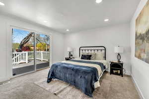 Bedroom featuring light colored carpet, access to outside, and recessed lighting