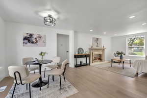 Dining area featuring wood finished floors, recessed lighting, and a glass covered fireplace