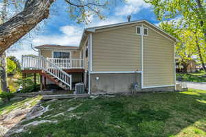 View of property exterior with a deck and a yard