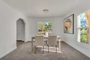 Dining room featuring carpet floors and arched walkways