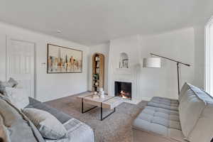 Carpeted living room featuring a high end fireplace