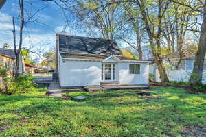 Back of property featuring a patio, stucco siding, french doors, a chimney, and roof with shingles